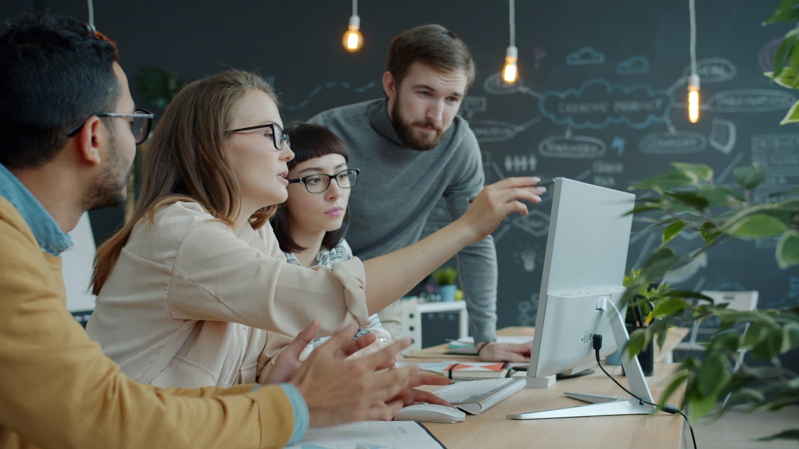 Equipo de trabajo revisando juntos una pantalla en la oficina